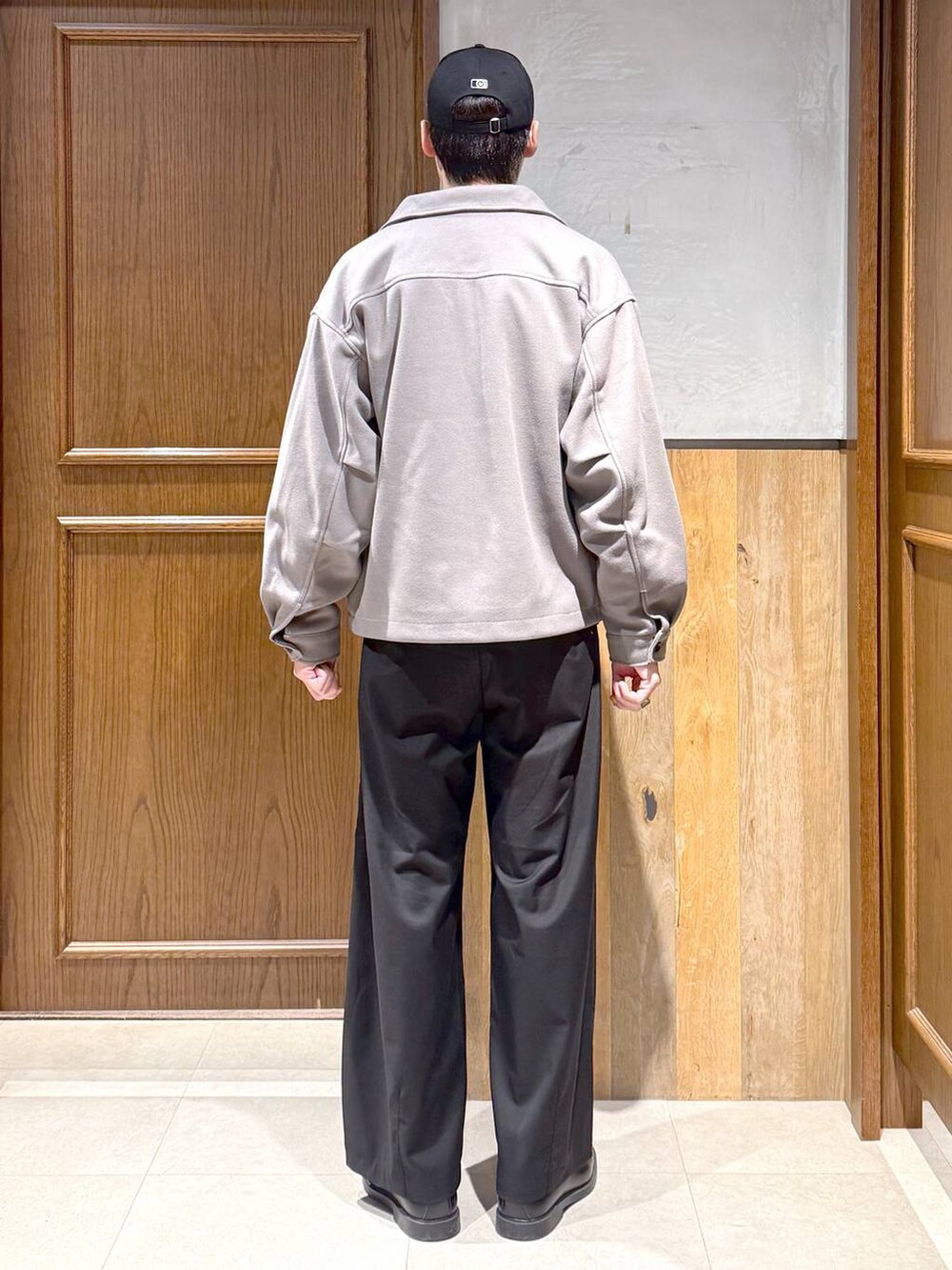 ベージュ系のブルゾン、ブラック系のニット/セーター、ブラック系のスラックスを着用したメンズの冬コーディネートの5枚目の写真