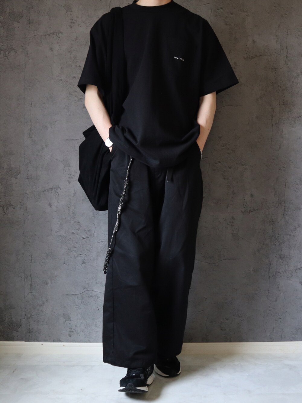 ブラック系のTシャツ/カットソー、ブラック系のチノパンツ、ブラック系のスニーカーを着用したメンズの春コーディネートの4枚目の写真