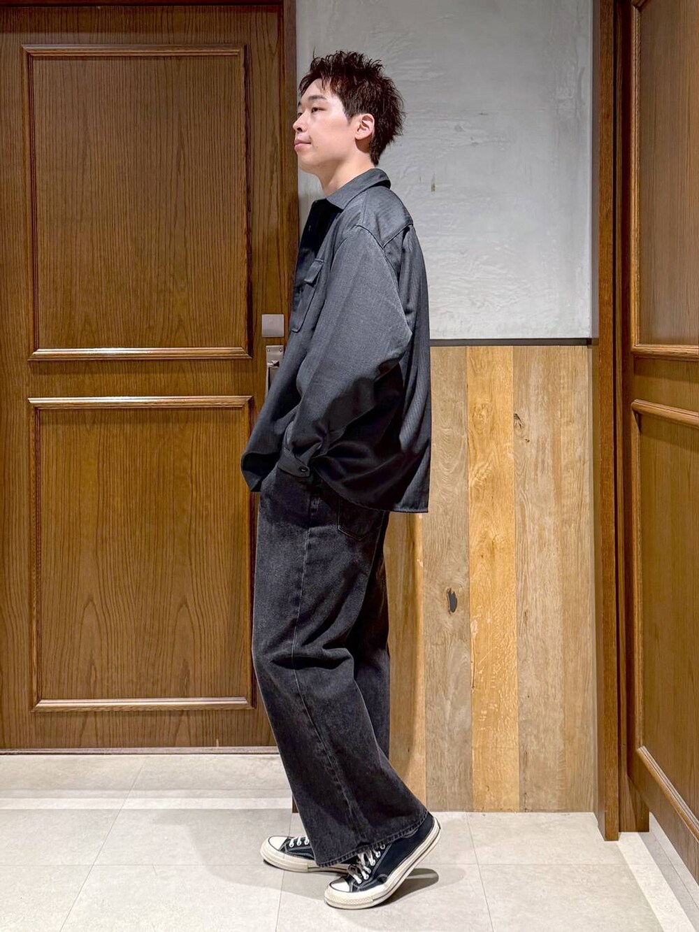 グレー系のブルゾン、ブラック系のデニムパンツ、ホワイト系のスウェットを着用したメンズの秋コーディネートの4枚目の写真