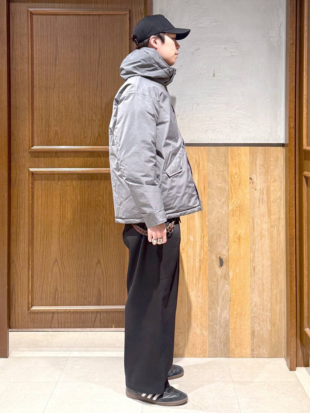 グレー系のダウンジャケット/コート、ブラック系のスラックス、レッド系のスウェットを着用したメンズの冬コーディネートの7枚目の写真