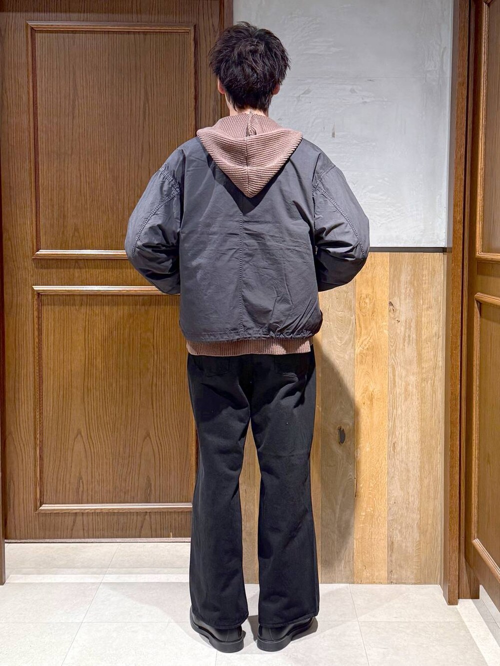 ブラック系のデニムパンツ、ブラック系のモッズコート、ブラウン系のニット/セーターを着用したメンズの冬コーディネートの5枚目の写真