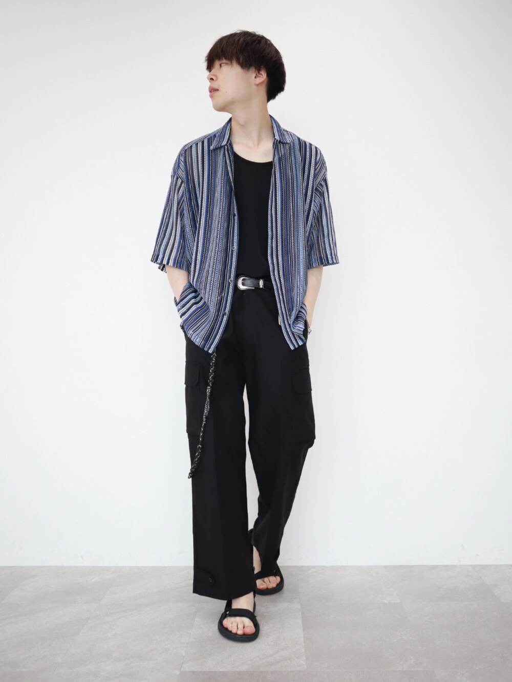 ブルー系のシャツ/ブラウス、ブラック系のカーゴパンツ、ブラック系のサンダルを着用したメンズの夏コーディネートの2枚目の写真