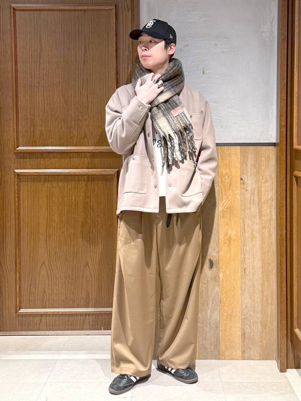 ホワイト系のニット/セーター、ベージュ系のブルゾン、ベージュ系のスラックスを着用したメンズの冬コーディネートの6枚目の写真