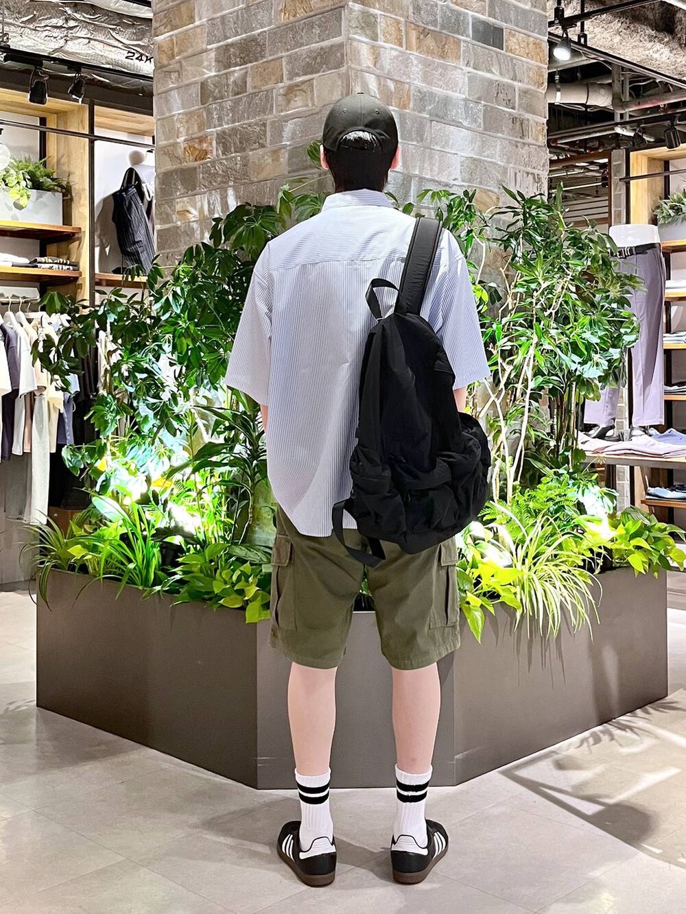 ブラック系のバックパック/リュック、ブルー系のシャツ/ブラウス、グリーン系のカーゴパンツを着用したメンズの夏コーディネートの4枚目の写真