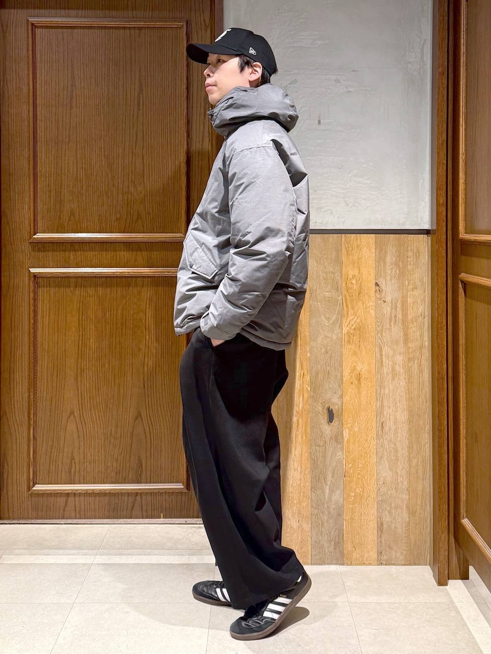 グレー系のダウンジャケット/コート、ブラック系のスラックス、レッド系のスウェットを着用したメンズの冬コーディネートの5枚目の写真