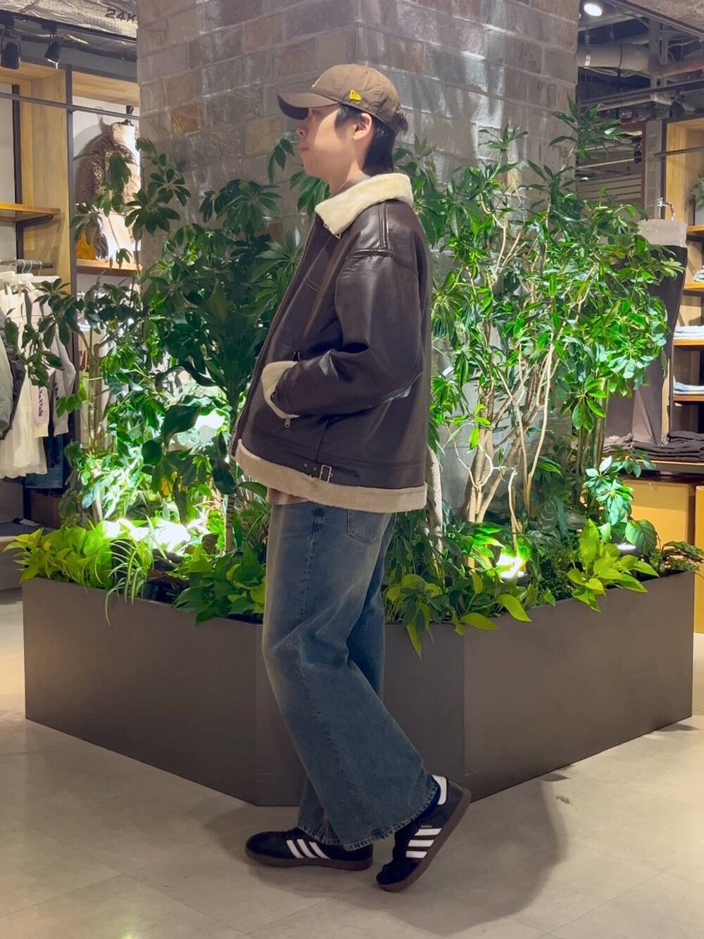 ブラウン系のムートンコート、ブルー系のデニムパンツ、ブルー系のデニムジャケットを着用したメンズの冬コーディネートの3枚目の写真