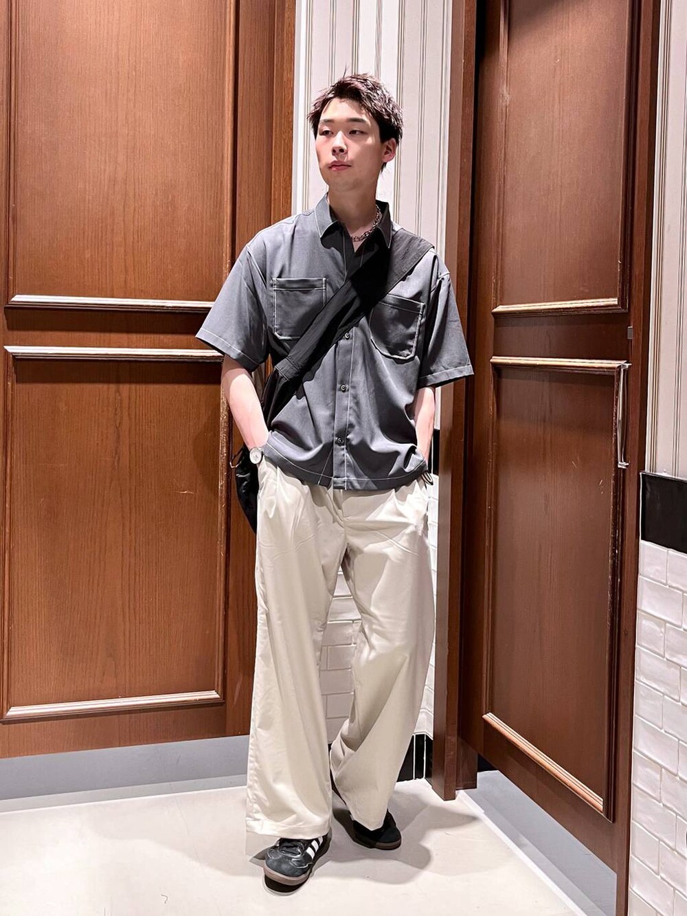 ホワイト系のスラックス、ブラック系のショルダーバッグ、グレー系のシャツ/ブラウスを着用したメンズの夏コーディネートの6枚目の写真