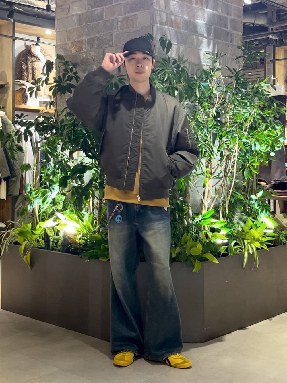 ブルー系のデニムパンツ、グリーン系のMA-1、イエロー系のスウェットを着用したメンズの秋コーディネートの2枚目の写真