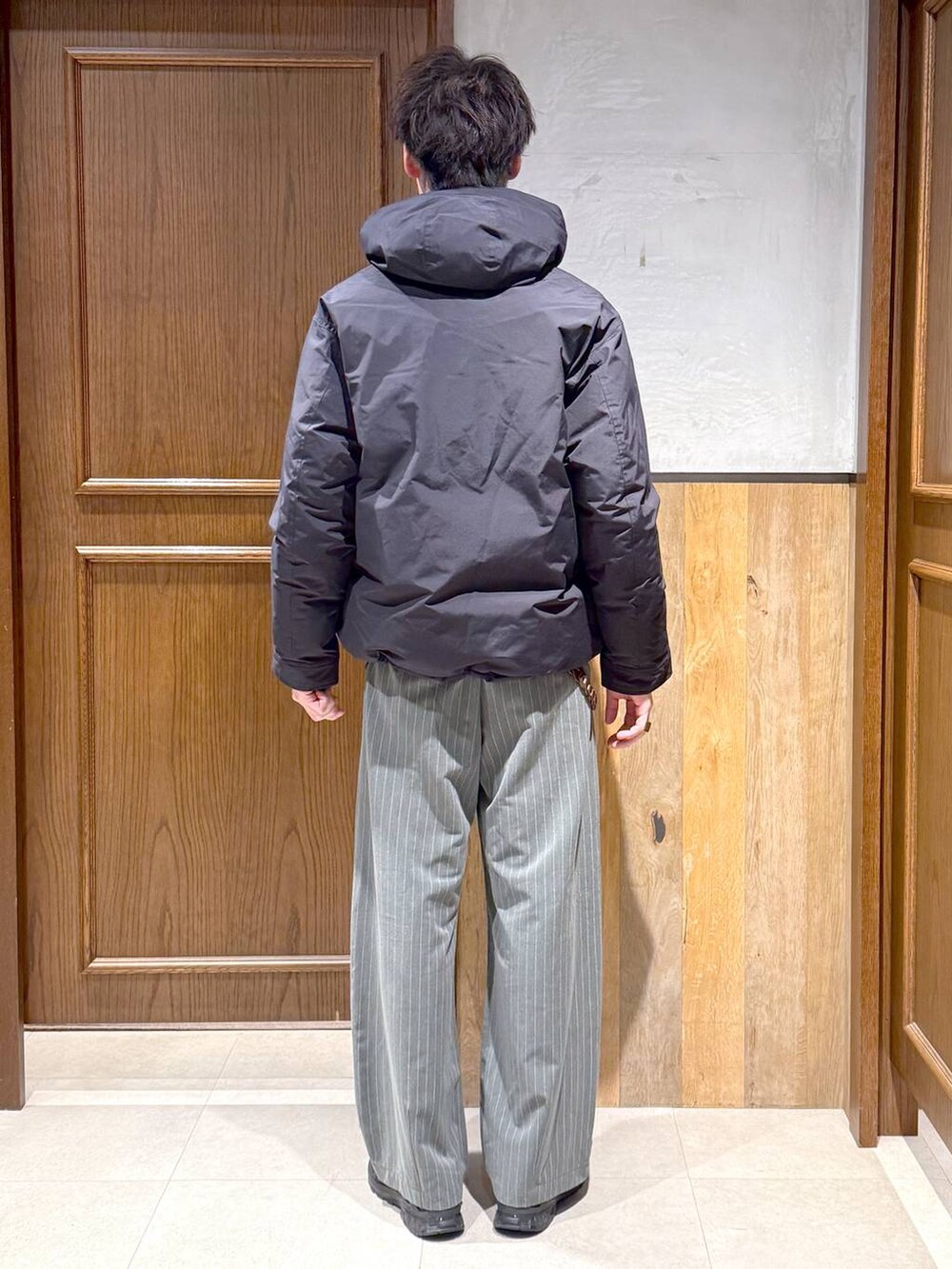 ブルー系のダウンジャケット/コート、その他のスウェット、グレー系のスラックスを着用したメンズの冬コーディネートの5枚目の写真