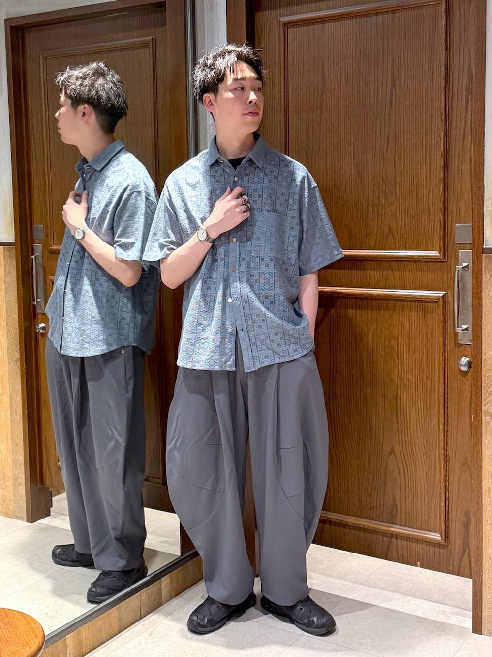 ブルー系のシャツ/ブラウス、グレー系のスラックス、ブラック系のTシャツ/カットソーを着用したメンズの夏コーディネートの2枚目の写真