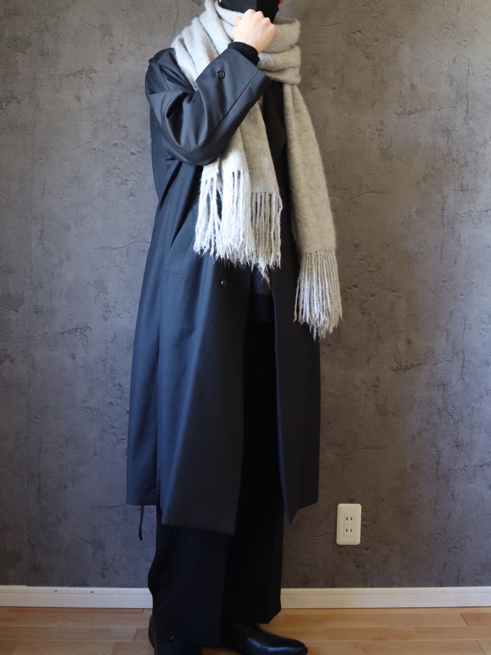 グレー系のニット/セーター、グレー系のトレンチコート、ブラック系のその他パンツを着用したメンズの冬コーディネートの3枚目の写真