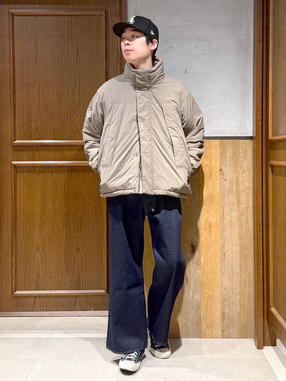 ブルー系のデニムパンツ、ブラウン系のダウンジャケット/コート、ブラウン系のニット/セーターを着用したメンズの冬コーディネートの4枚目の写真