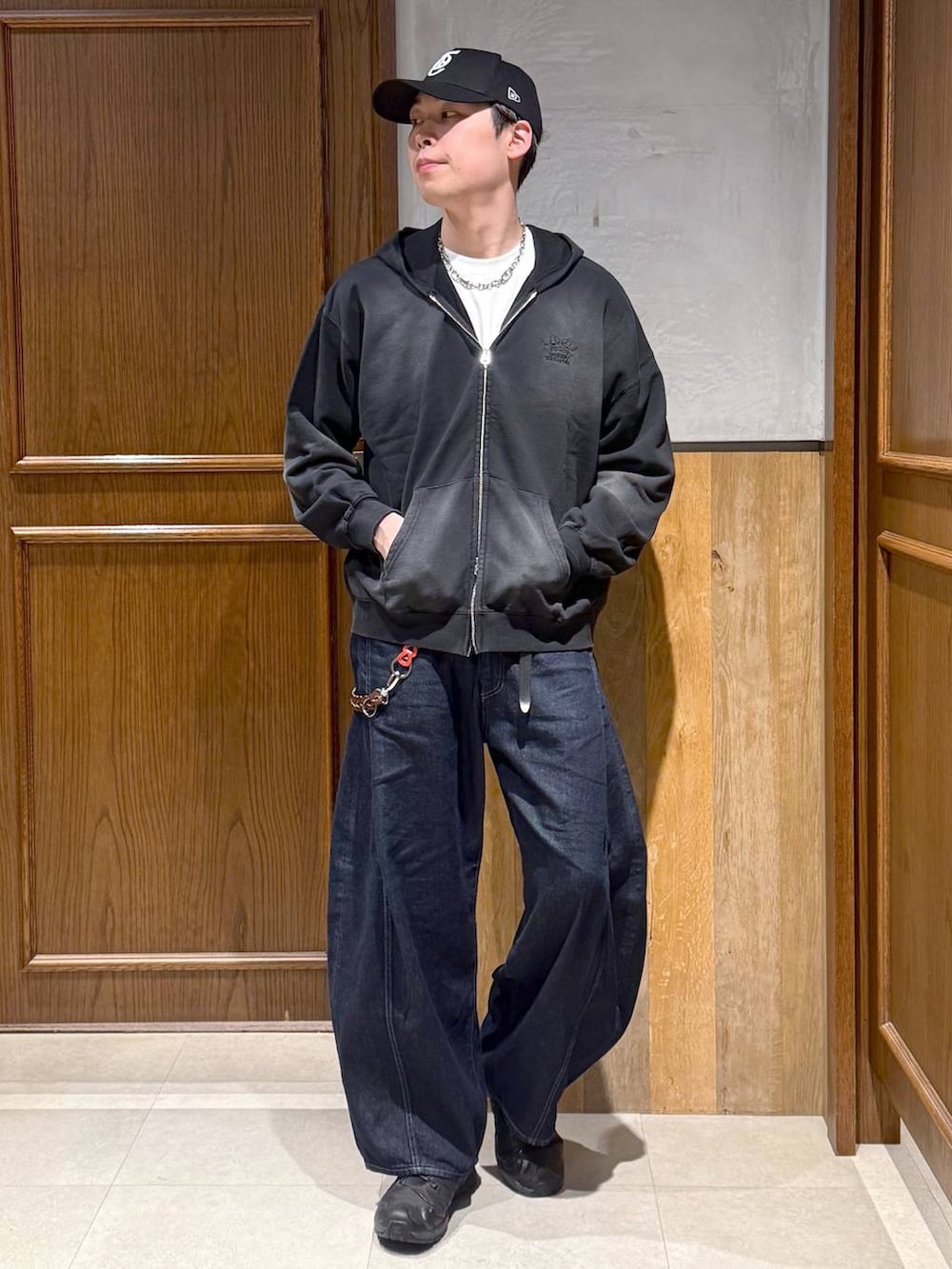 ホワイト系のTシャツ/カットソー、ブラック系のパーカー、ブルー系のデニムパンツを着用したメンズの春コーディネートの2枚目の写真