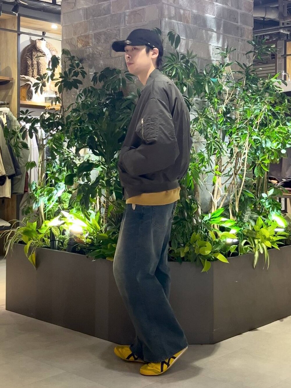 ブルー系のデニムパンツ、グリーン系のMA-1、イエロー系のスウェットを着用したメンズの秋コーディネートの3枚目の写真