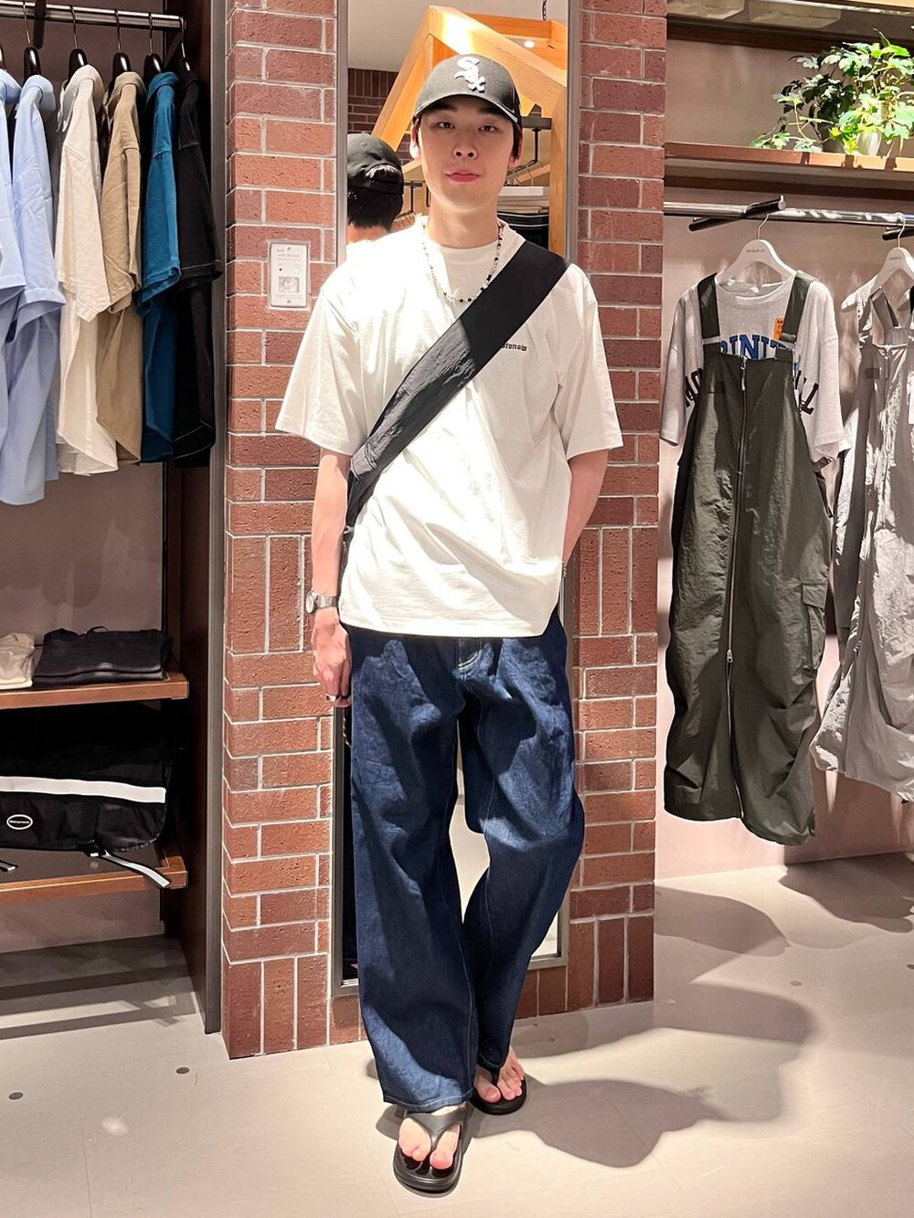 ブルー系のデニムパンツ、ブラック系のショルダーバッグ、ホワイト系のTシャツ/カットソーを着用したメンズの夏コーディネートの4枚目の写真