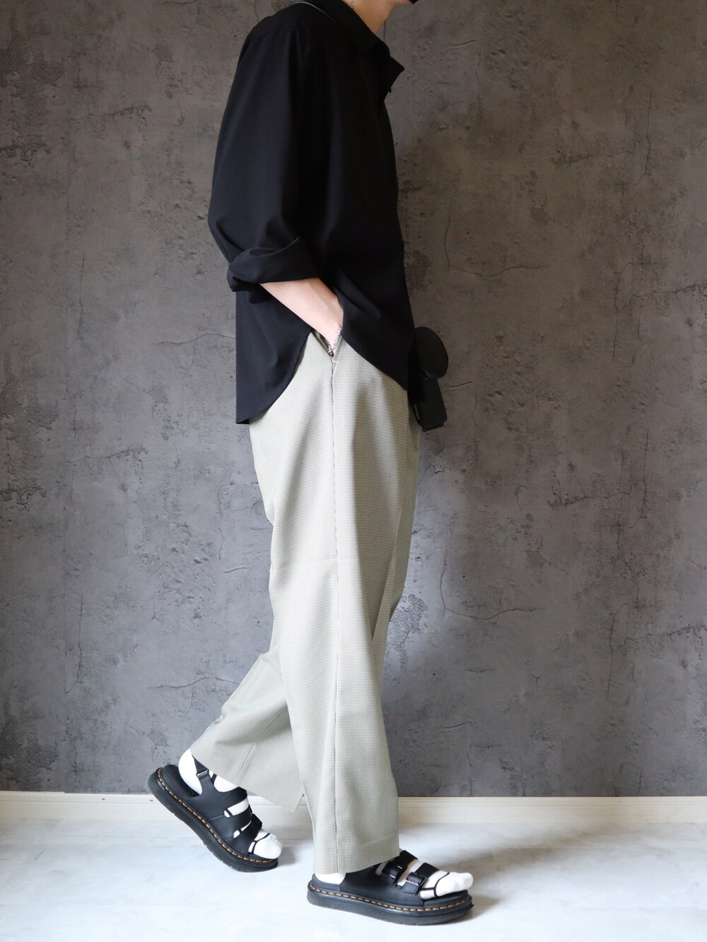 ブラック系のシャツ/ブラウス、ブラック系のショルダーバッグ、ベージュ系のスラックスを着用したメンズの夏コーディネートの2枚目の写真