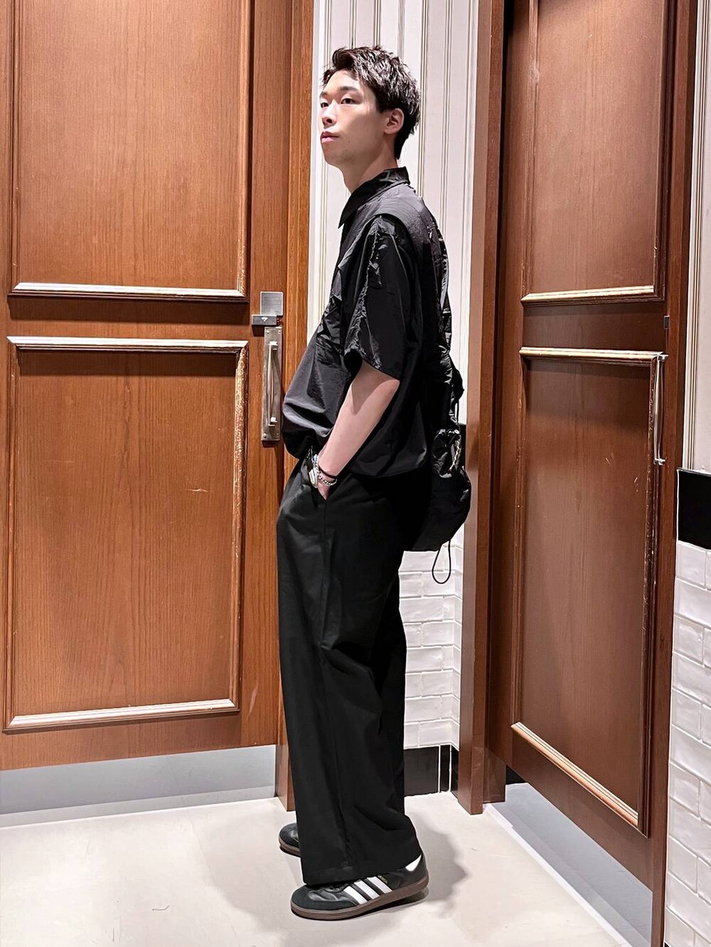 ブラック系のスラックス、ブラック系のショルダーバッグ、ブラック系のシャツ/ブラウスを着用したメンズの夏コーディネートの3枚目の写真