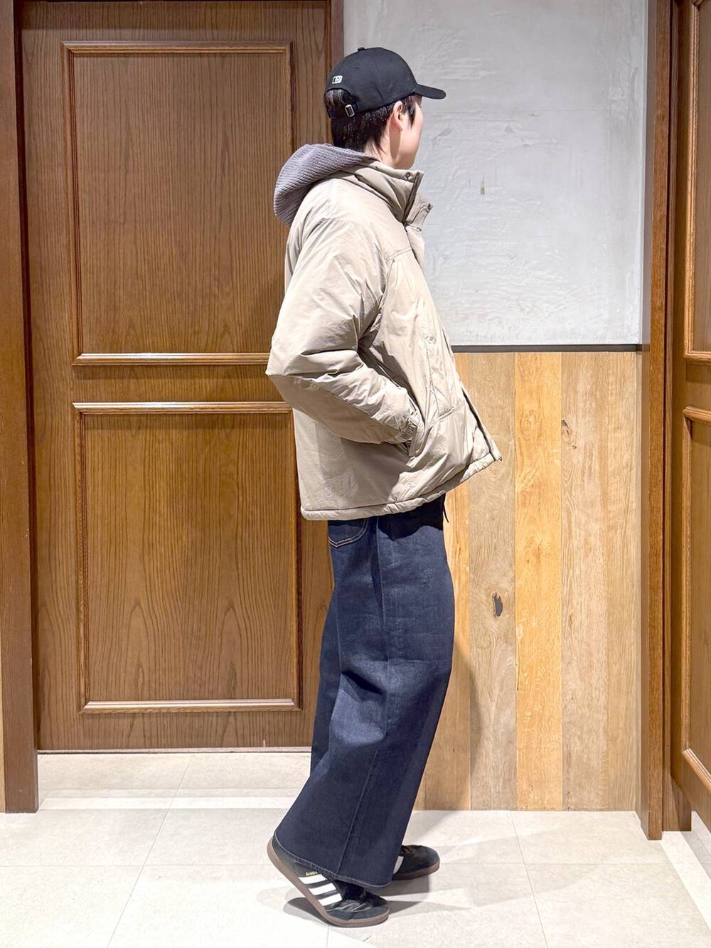 ブルー系のデニムパンツ、ブラウン系のダウンジャケット/コート、グレー系のニット/セーターを着用したメンズの冬コーディネートの5枚目の写真