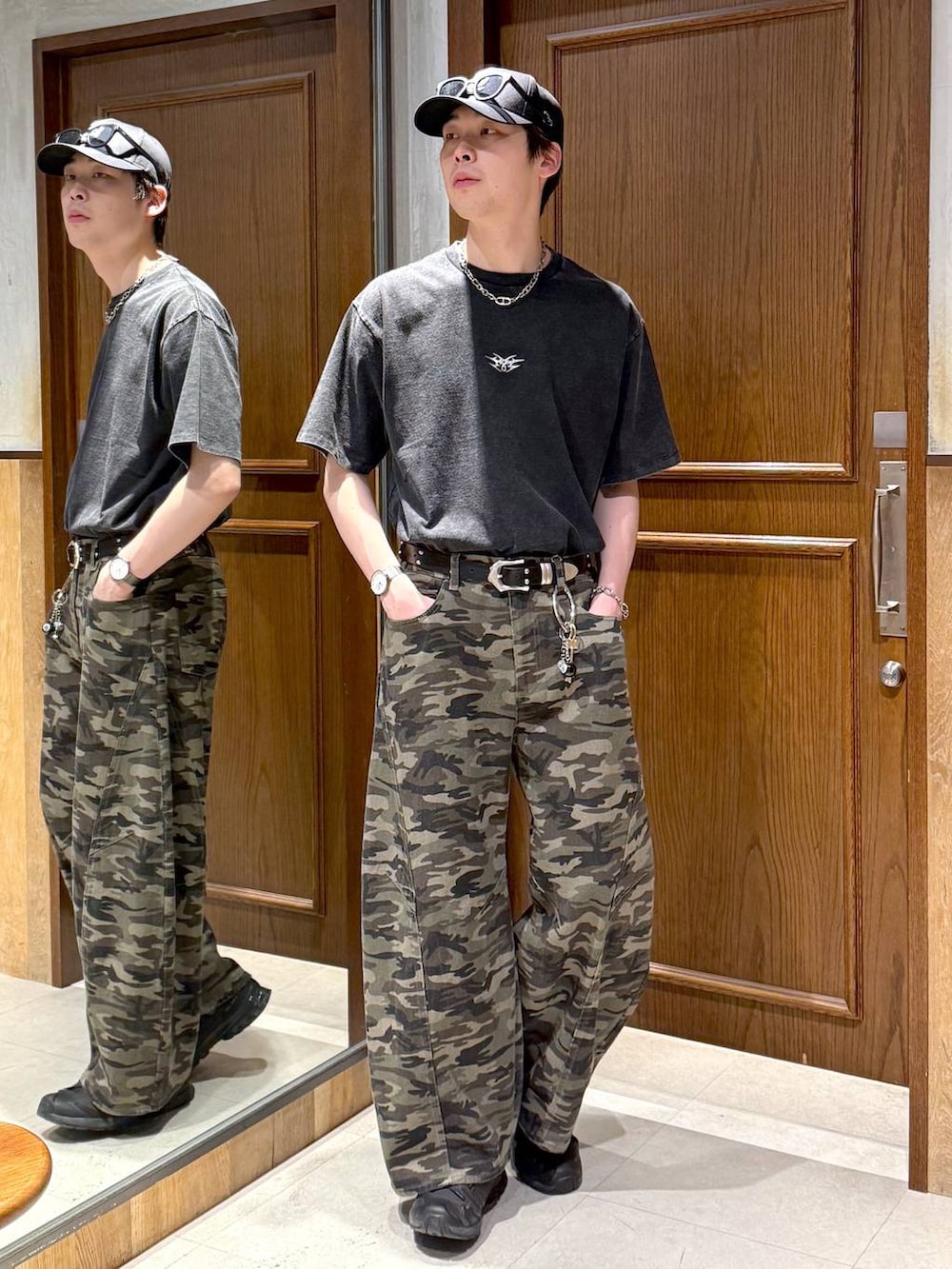 グリーン系のデニムパンツ、ブラック系のTシャツ/カットソー、ブラック系のキーホルダーを着用したメンズの春コーディネートの2枚目の写真