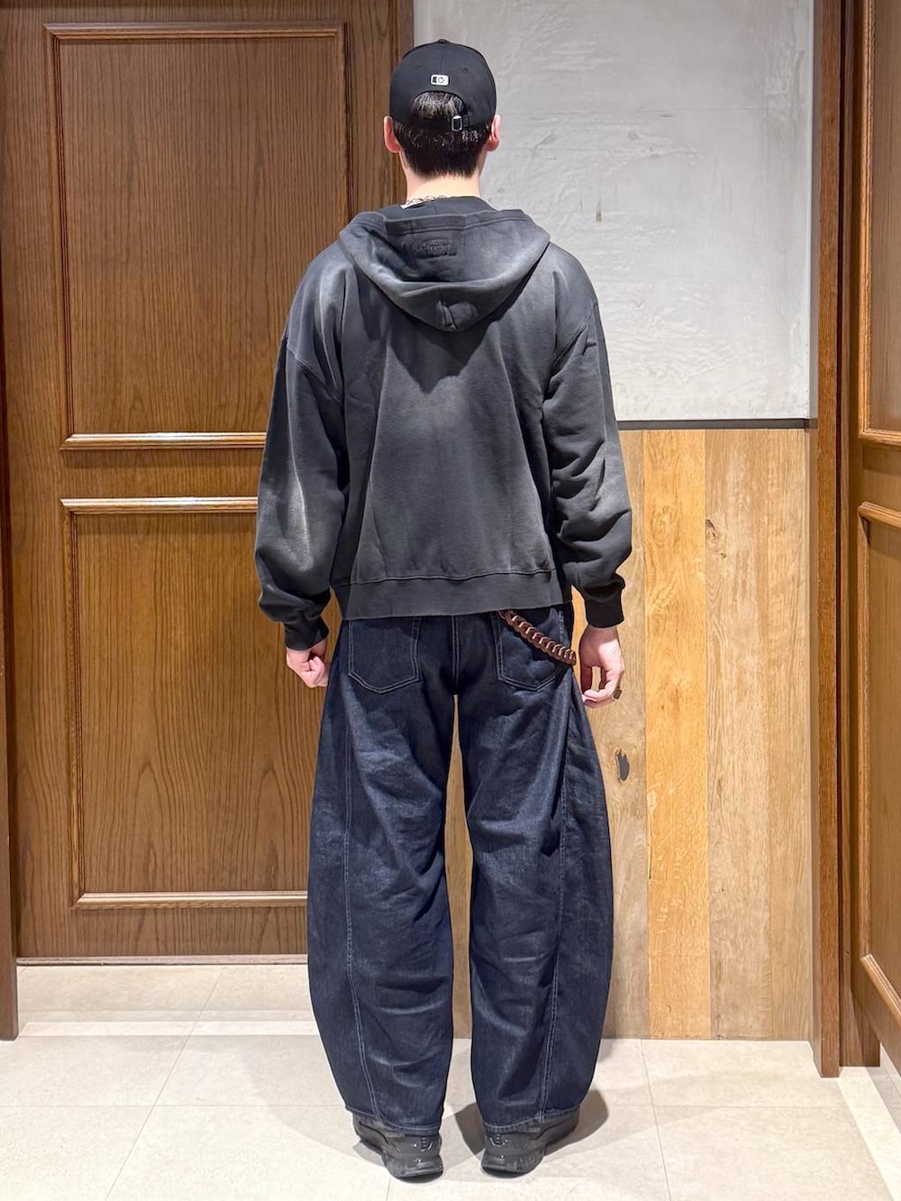 ホワイト系のTシャツ/カットソー、ブラック系のパーカー、ブルー系のデニムパンツを着用したメンズの春コーディネートの4枚目の写真