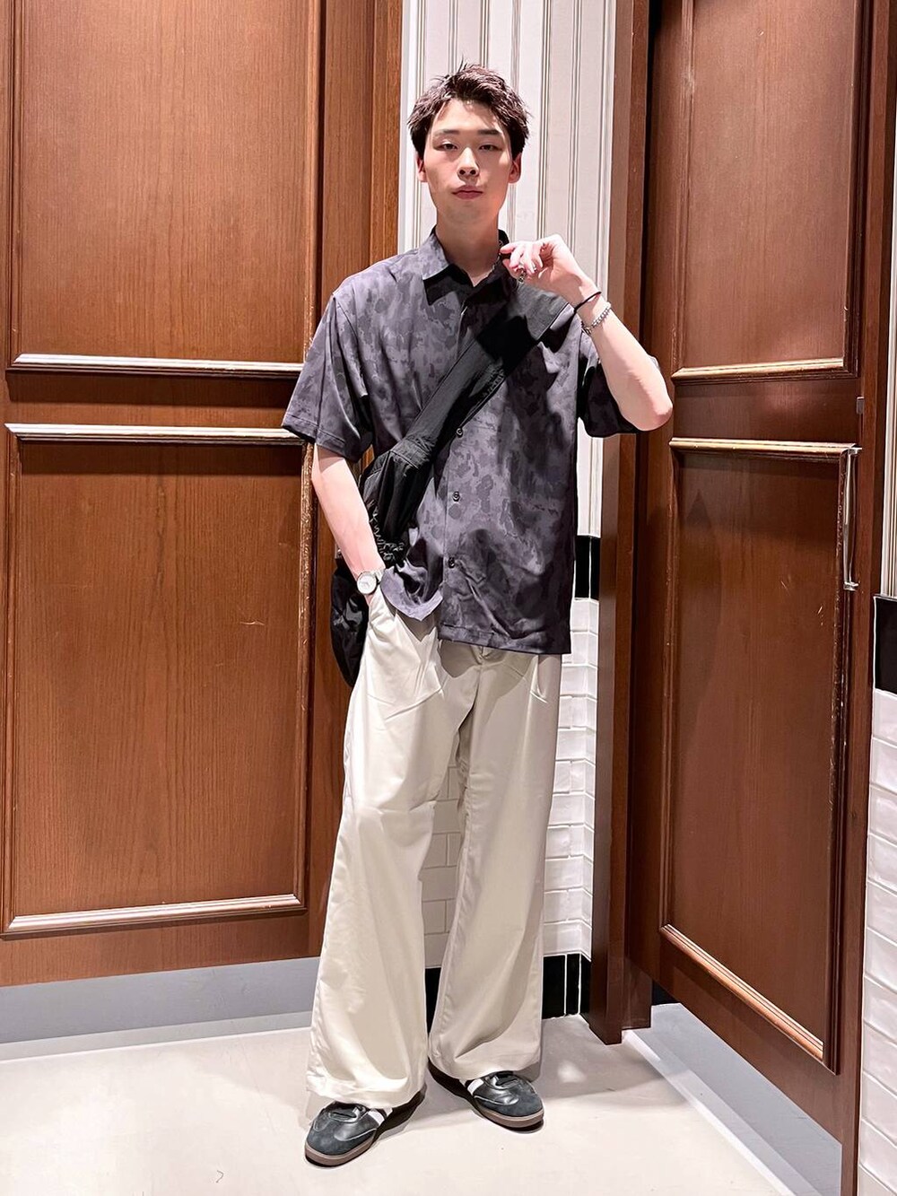 ホワイト系のスラックス、ブラック系のシャツ/ブラウス、ブラック系のショルダーバッグを着用したメンズの夏コーディネートの2枚目の写真