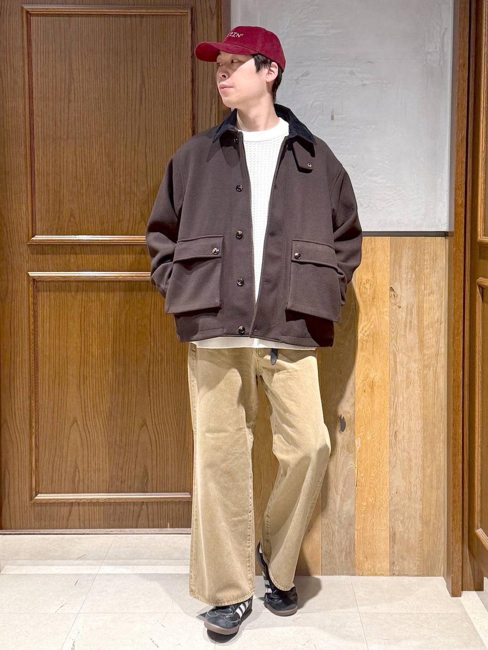 ブラウン系のブルゾン、ホワイト系のニット/セーター、ベージュ系のデニムパンツを着用したメンズの冬コーディネートの4枚目の写真