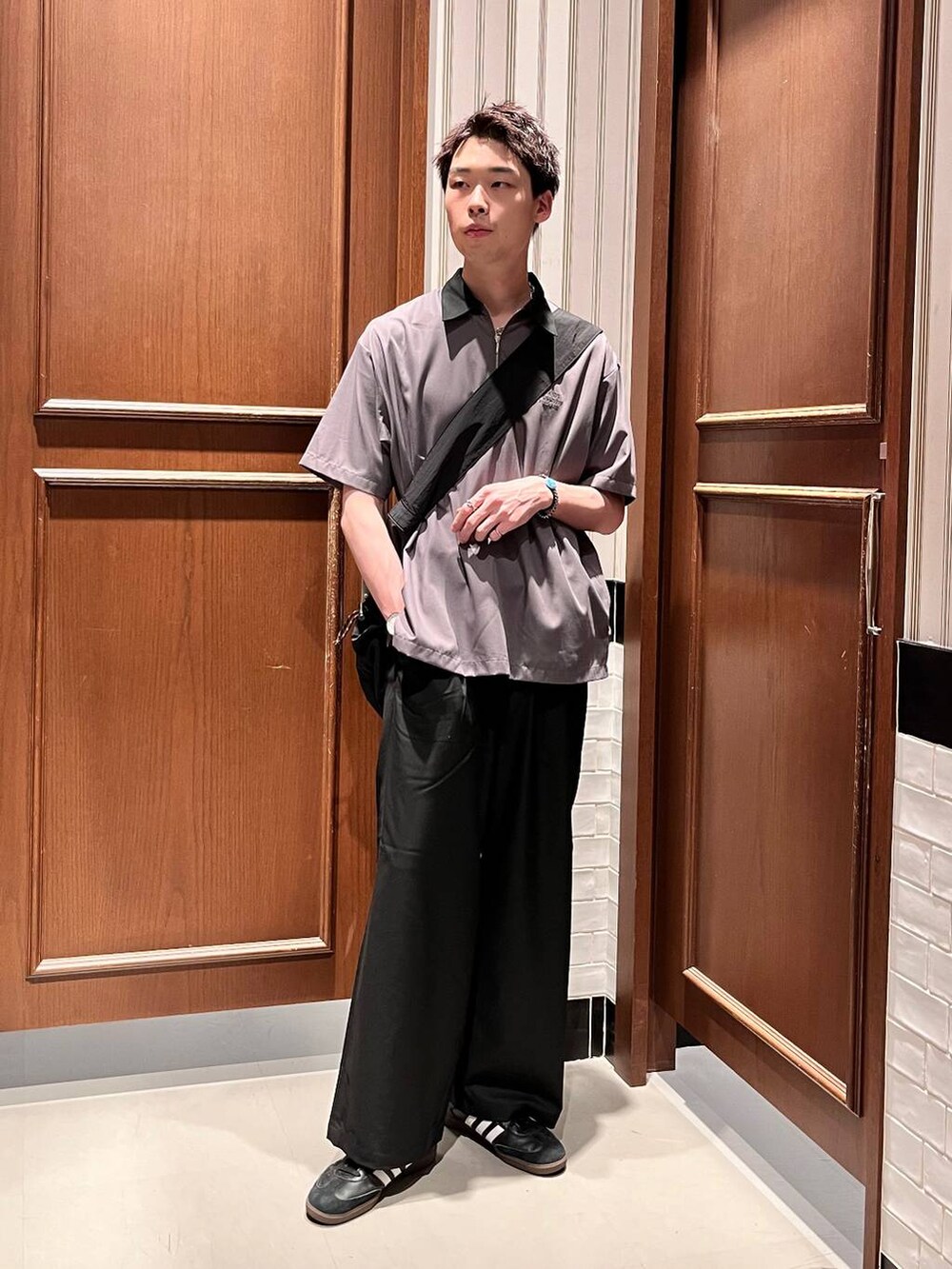 ブラック系のスラックス、ブラック系のショルダーバッグ、グレー系のシャツ/ブラウスを着用したメンズの夏コーディネートの6枚目の写真