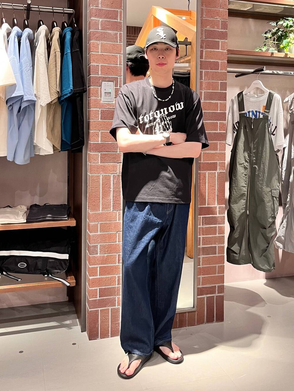 ブルー系のデニムパンツ、ブラック系のTシャツ/カットソー、パープル系のネックレスを着用したメンズの夏コーディネートの6枚目の写真