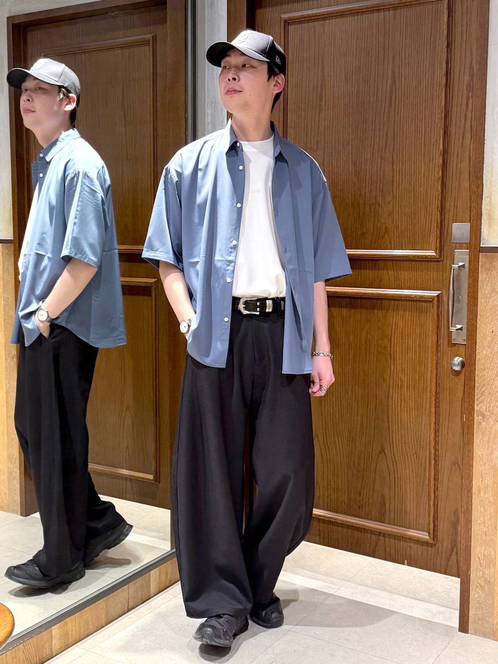 ブルー系のシャツ/ブラウス、ホワイト系のTシャツ/カットソー、ブラック系のスラックスを着用したメンズの春コーディネートの2枚目の写真