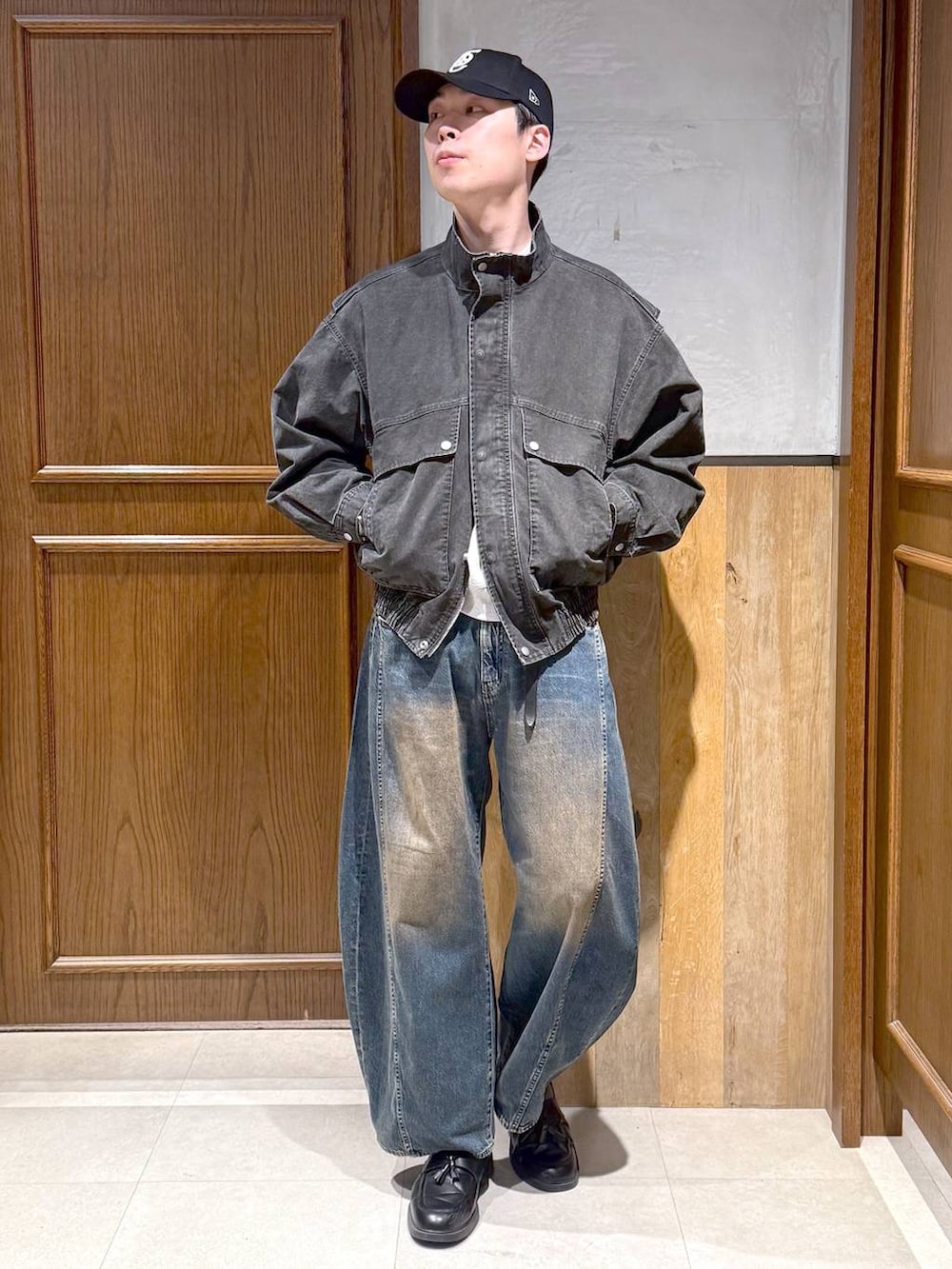 グレー系のスウェット、グレー系のブルゾン、ブルー系のデニムパンツを着用したメンズの春コーディネートの2枚目の写真