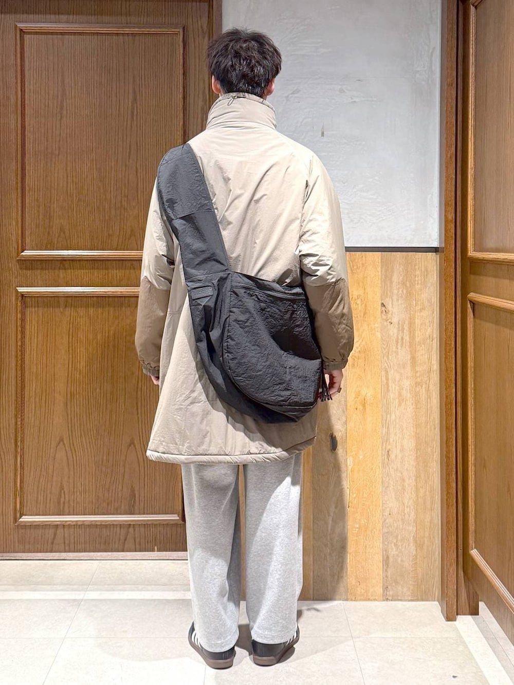 グリーン系のダウンジャケット/コート、ブラック系のポロシャツ、グレー系のスウェットパンツを着用したメンズの秋コーディネートの6枚目の写真