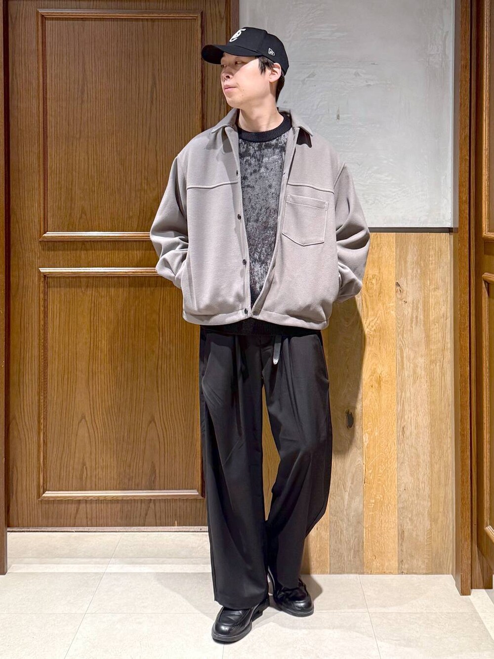 ベージュ系のブルゾン、ブラック系のニット/セーター、ブラック系のスラックスを着用したメンズの冬コーディネートの3枚目の写真