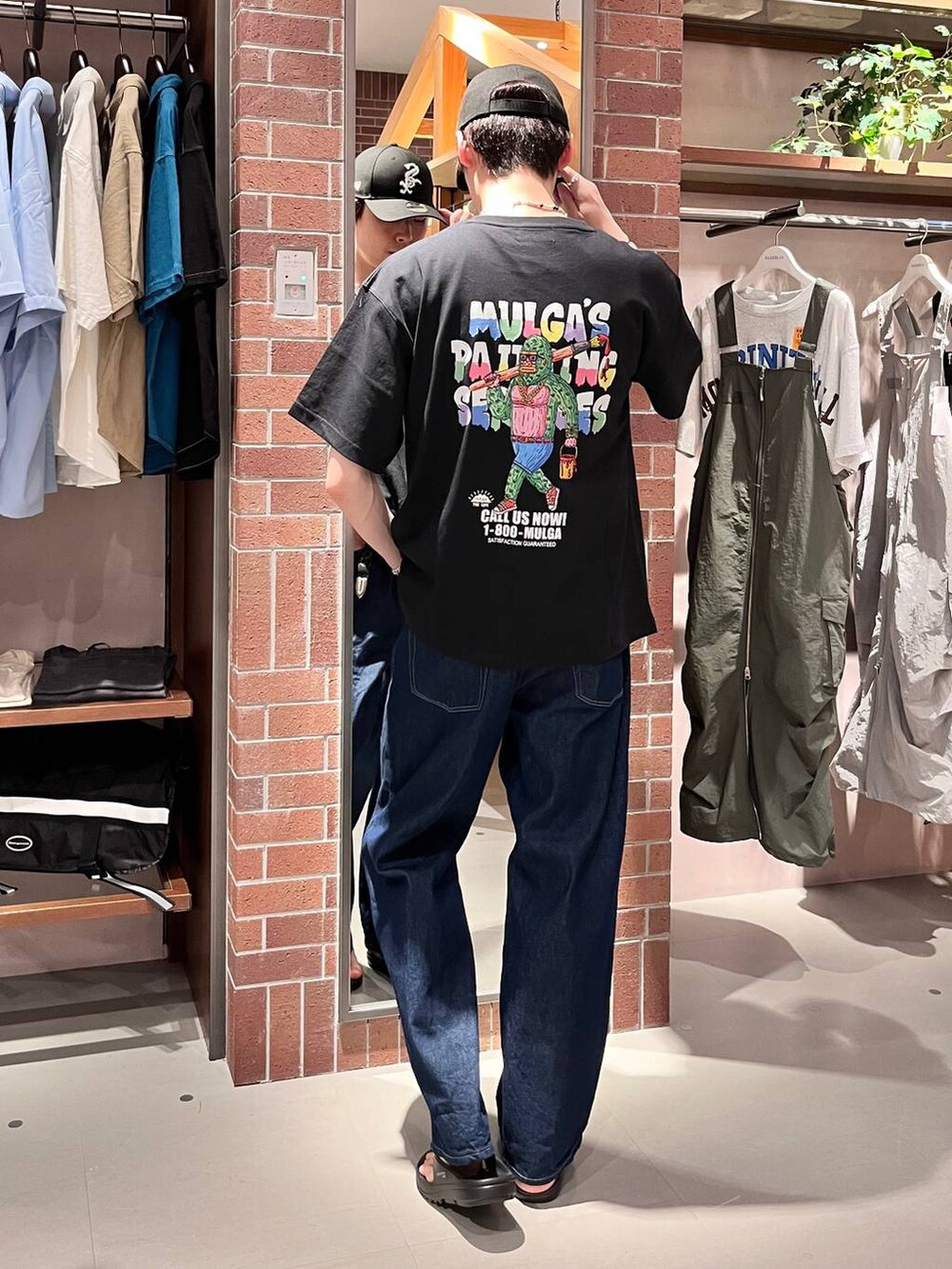 ブルー系のデニムパンツ、ブラック系のTシャツ/カットソー、パープル系のネックレスを着用したメンズの夏コーディネートの2枚目の写真