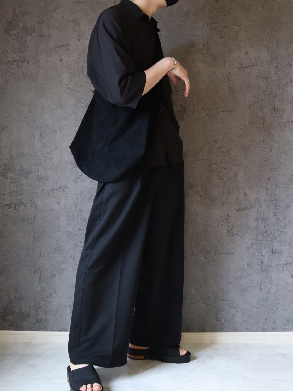 ブラック系のシャツ/ブラウス、ブラック系のスラックス、ブラック系のサンダルを着用したメンズの夏コーディネートの3枚目の写真