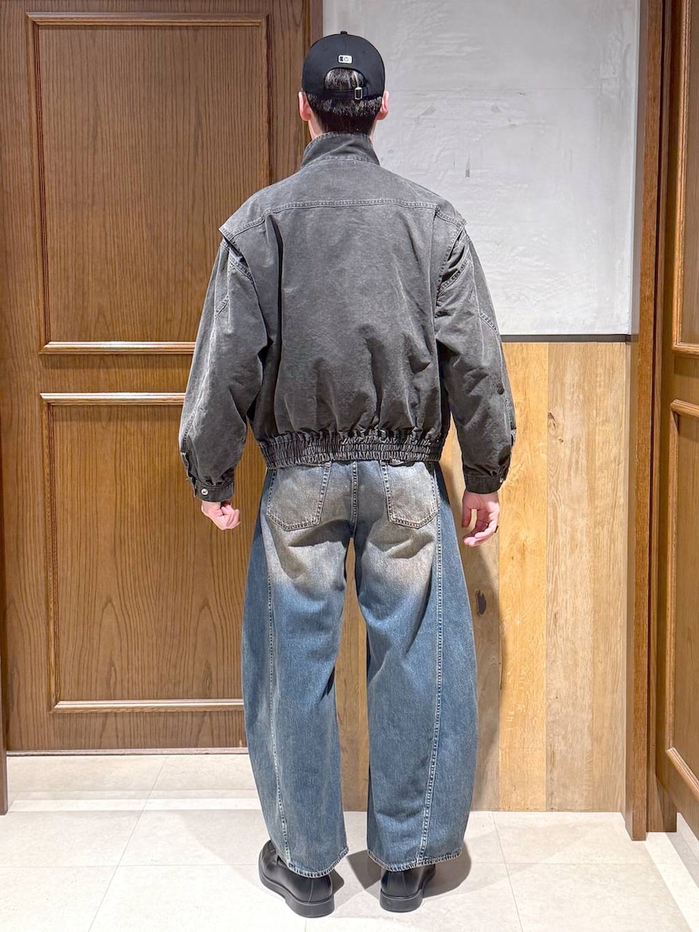 グレー系のスウェット、グレー系のブルゾン、ブルー系のデニムパンツを着用したメンズの春コーディネートの4枚目の写真