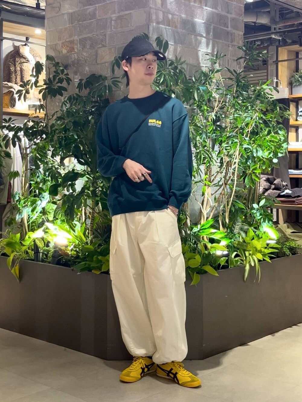 ホワイト系のカーゴパンツ、ブラック系のショルダーバッグ、グリーン系のスウェットを着用したメンズの秋コーディネートの2枚目の写真