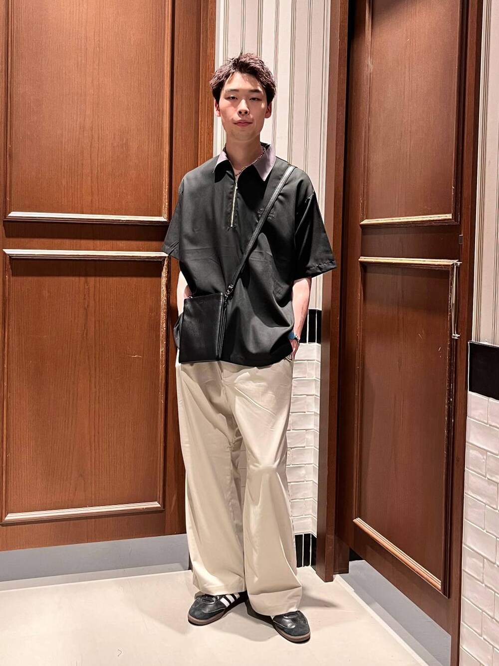 ホワイト系のスラックス、ブラック系のシャツ/ブラウス、ブラック系のショルダーバッグを着用したメンズの夏コーディネートの7枚目の写真