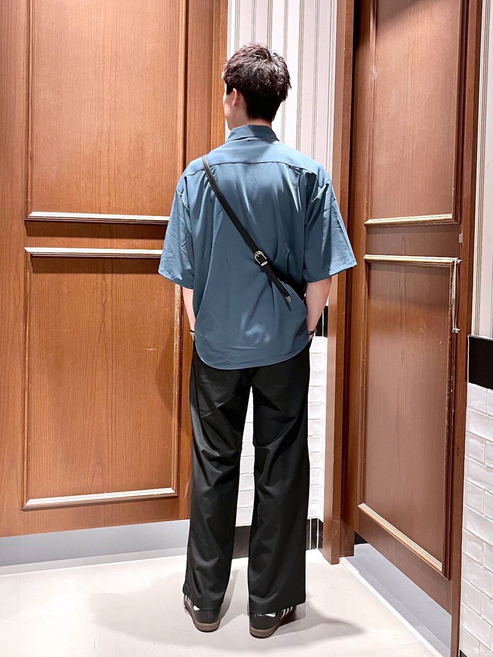 ブラック系のスラックス、ブラック系のショルダーバッグ、ブルー系のシャツ/ブラウスを着用したメンズの夏コーディネートの4枚目の写真