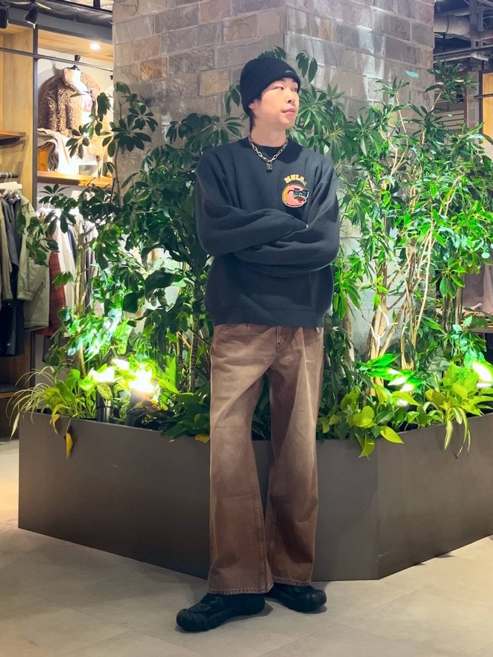 ブラウン系のデニムパンツ、グリーン系のニット/セーターを着用したメンズの冬コーディネートの2枚目の写真