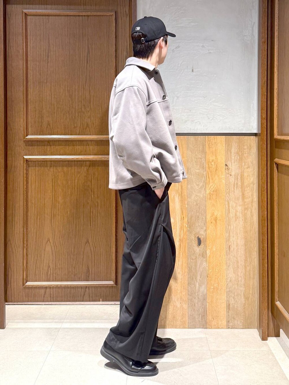 ベージュ系のブルゾン、ブラック系のニット/セーター、ブラック系のスラックスを着用したメンズの冬コーディネートの6枚目の写真