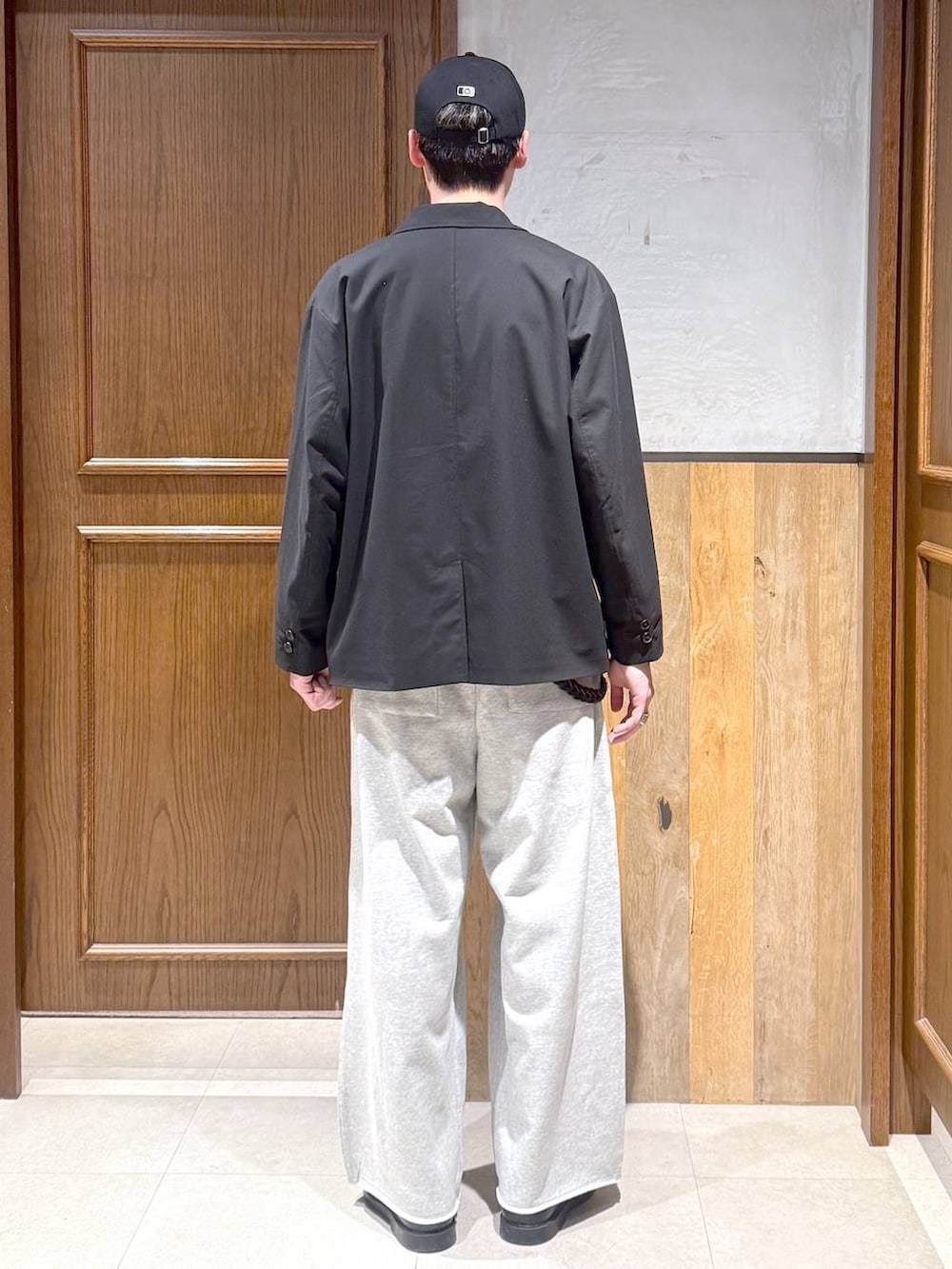 ブラック系のテーラードジャケット、ホワイト系のTシャツ/カットソー、グレー系のスウェットパンツを着用したメンズの春コーディネートの5枚目の写真