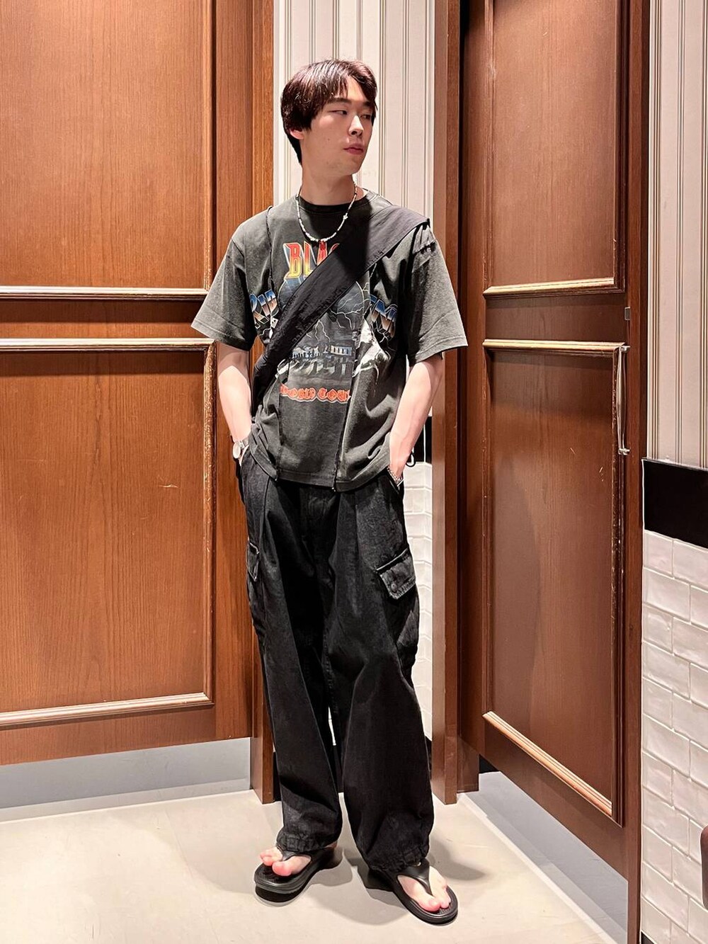 グレー系のデニムパンツ、ブラック系のショルダーバッグ、ブラック系のサンダルを着用したメンズの夏コーディネートの6枚目の写真