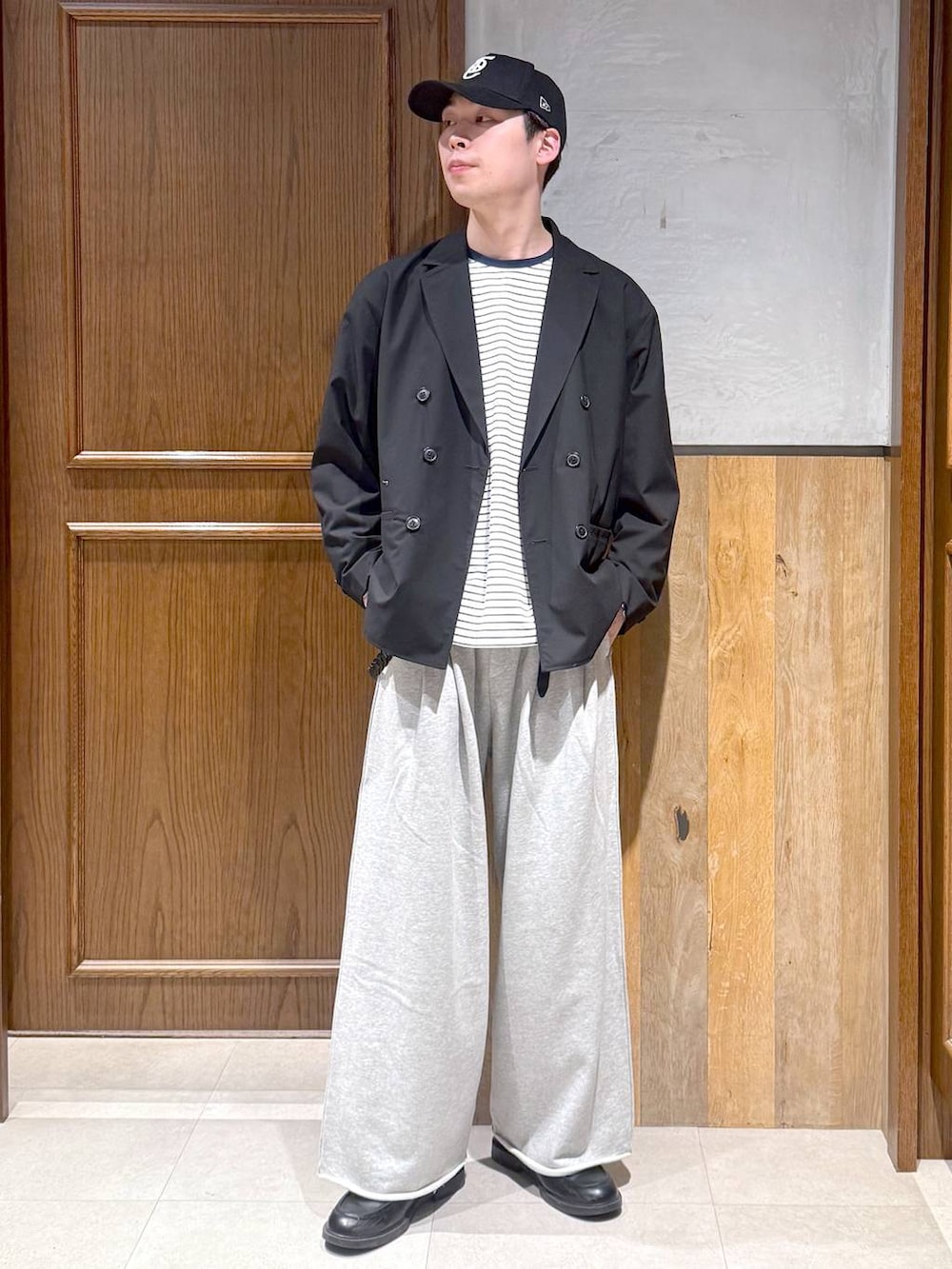 ブラック系のテーラードジャケット、ホワイト系のTシャツ/カットソー、グレー系のスウェットパンツを着用したメンズの春コーディネートの2枚目の写真