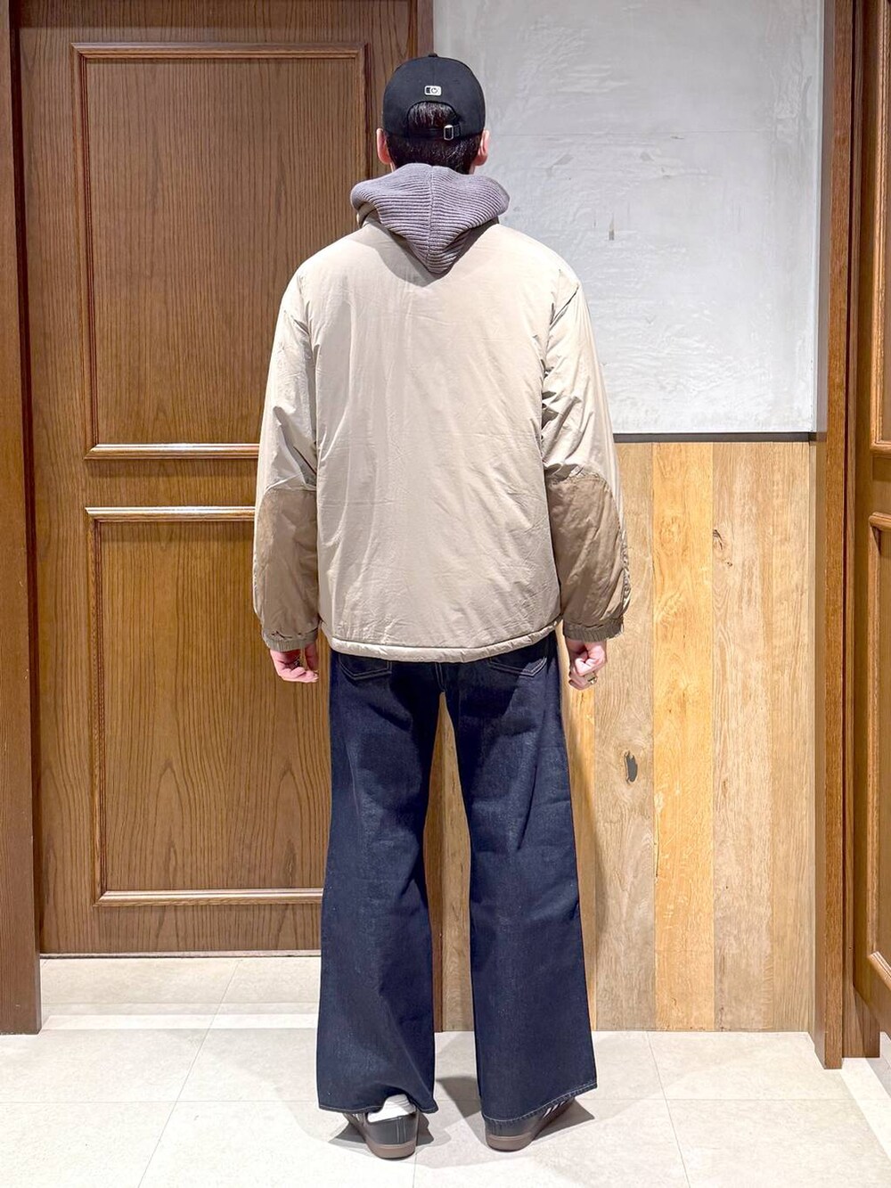 ブルー系のデニムパンツ、ブラウン系のダウンジャケット/コート、グレー系のニット/セーターを着用したメンズの冬コーディネートの4枚目の写真