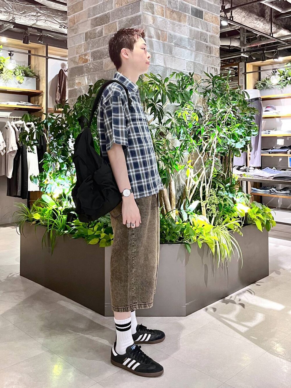 ブラック系のバックパック/リュック、ホワイト系のタンクトップ、グレー系のデニムパンツを着用したメンズの夏コーディネートの5枚目の写真