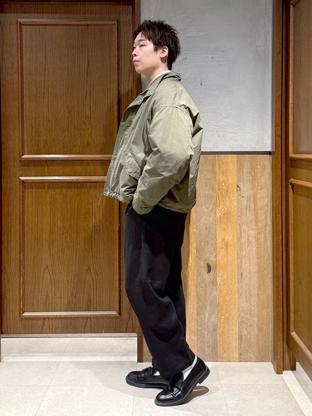 グリーン系のモッズコート、ブラック系のスラックス、ホワイト系のシャツ/ブラウスを着用したメンズの冬コーディネートの4枚目の写真