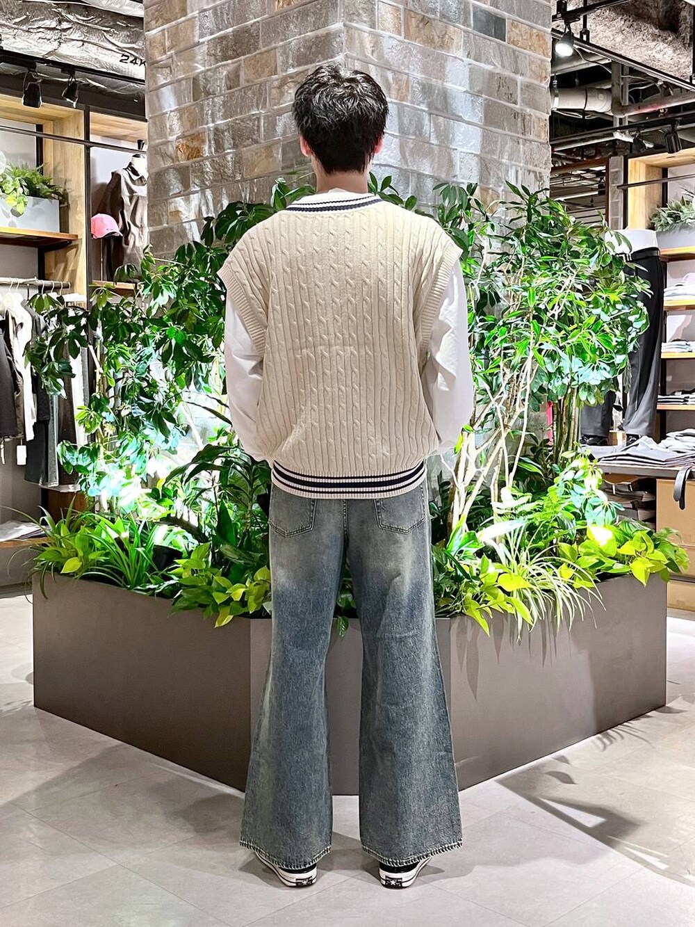 ブラック系のテーラードジャケット、ブルー系のデニムパンツ、ホワイト系のニット/セーターを着用したメンズの春コーディネートの4枚目の写真