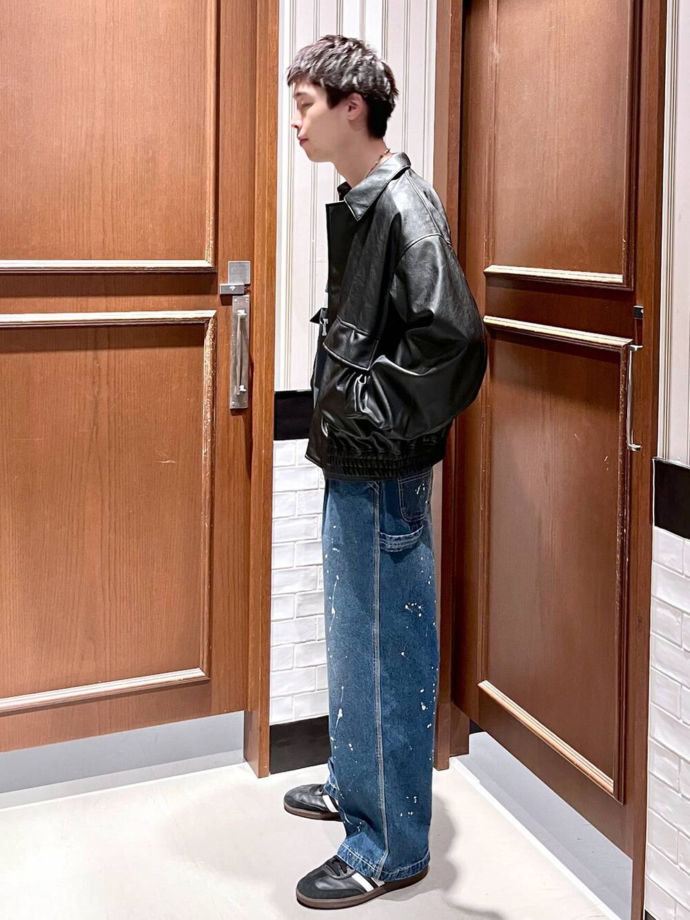 ブラック系のブルゾン、ブルー系のデニムパンツを着用したメンズの夏コーディネートの5枚目の写真