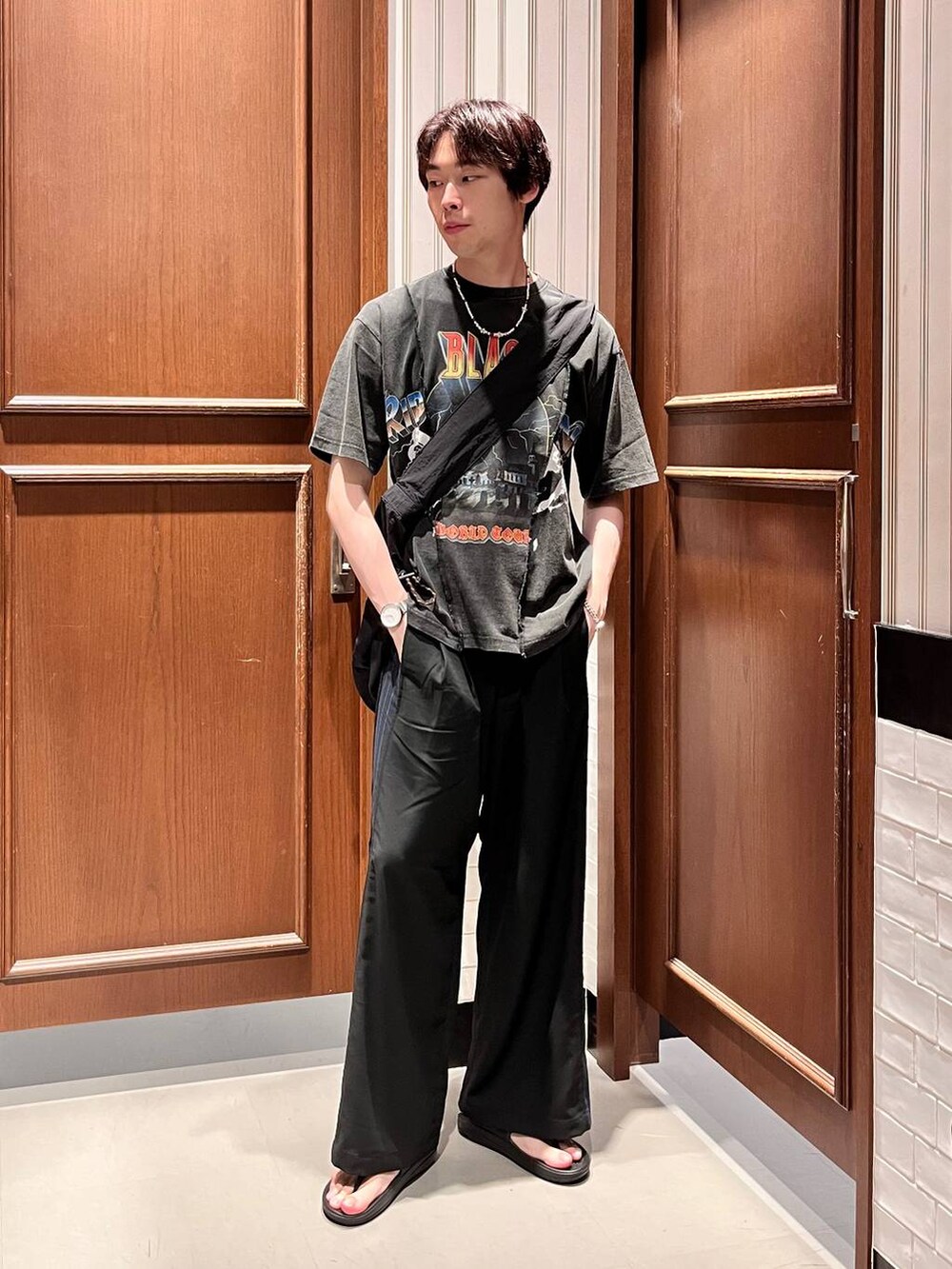 ブラック系のサンダル、ブラック系のショルダーバッグ、ブラック系のスラックスを着用したメンズの夏コーディネートの2枚目の写真