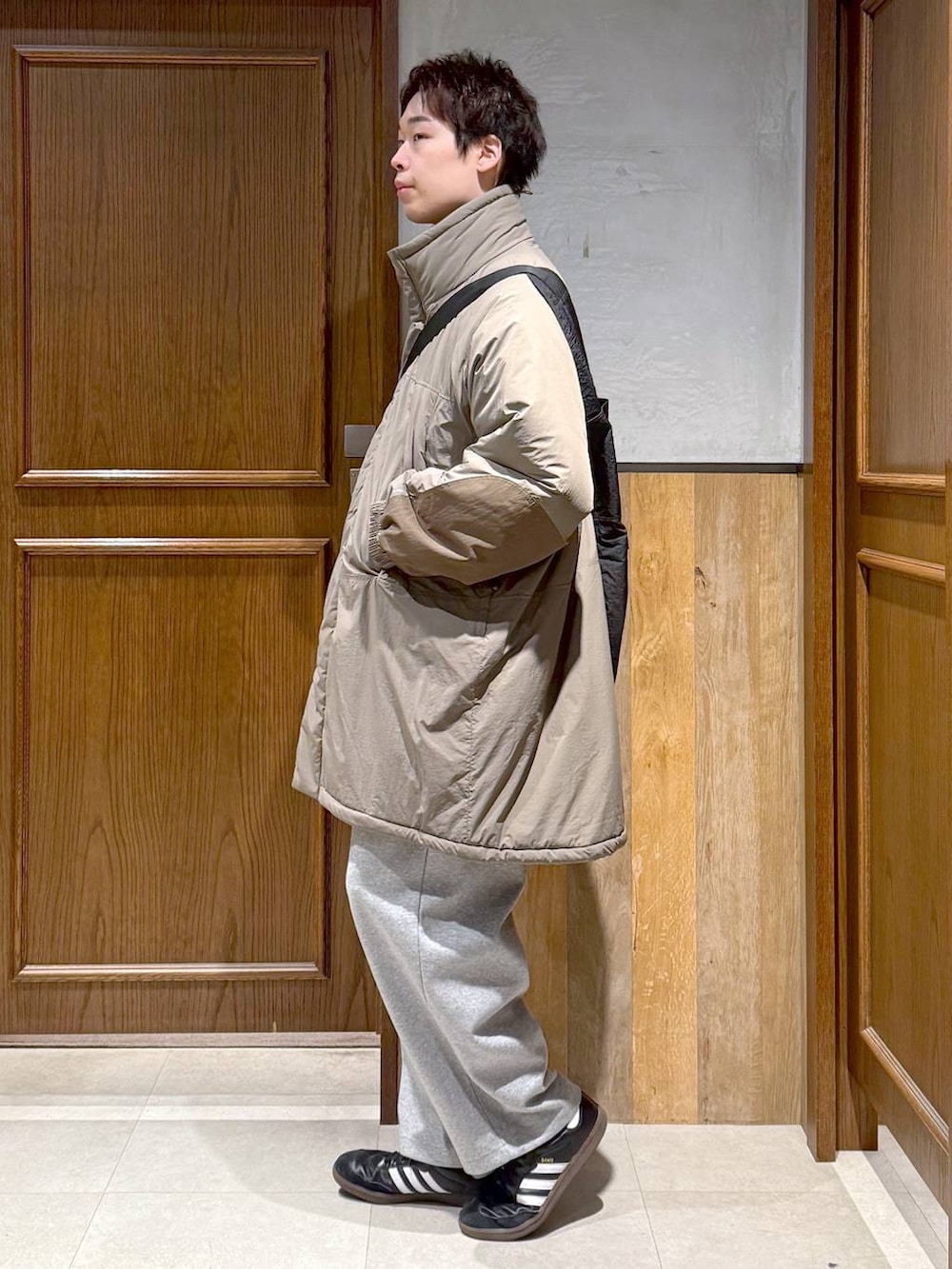 グリーン系のダウンジャケット/コート、ブラック系のポロシャツ、グレー系のスウェットパンツを着用したメンズの秋コーディネートの5枚目の写真